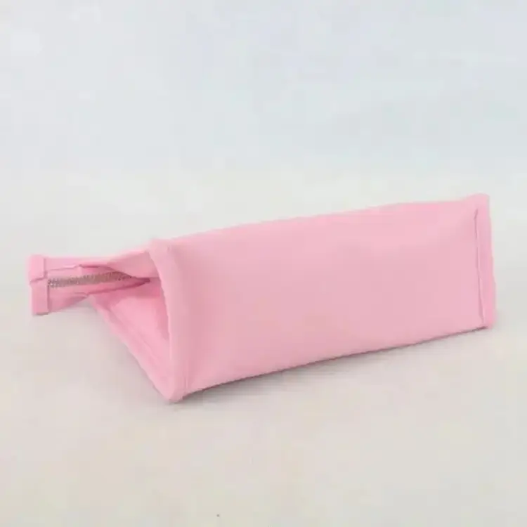 Interior view of a spacious pink toiletry bag, used as a travel organizer for makeup brushes, palettes, and skincare essentials